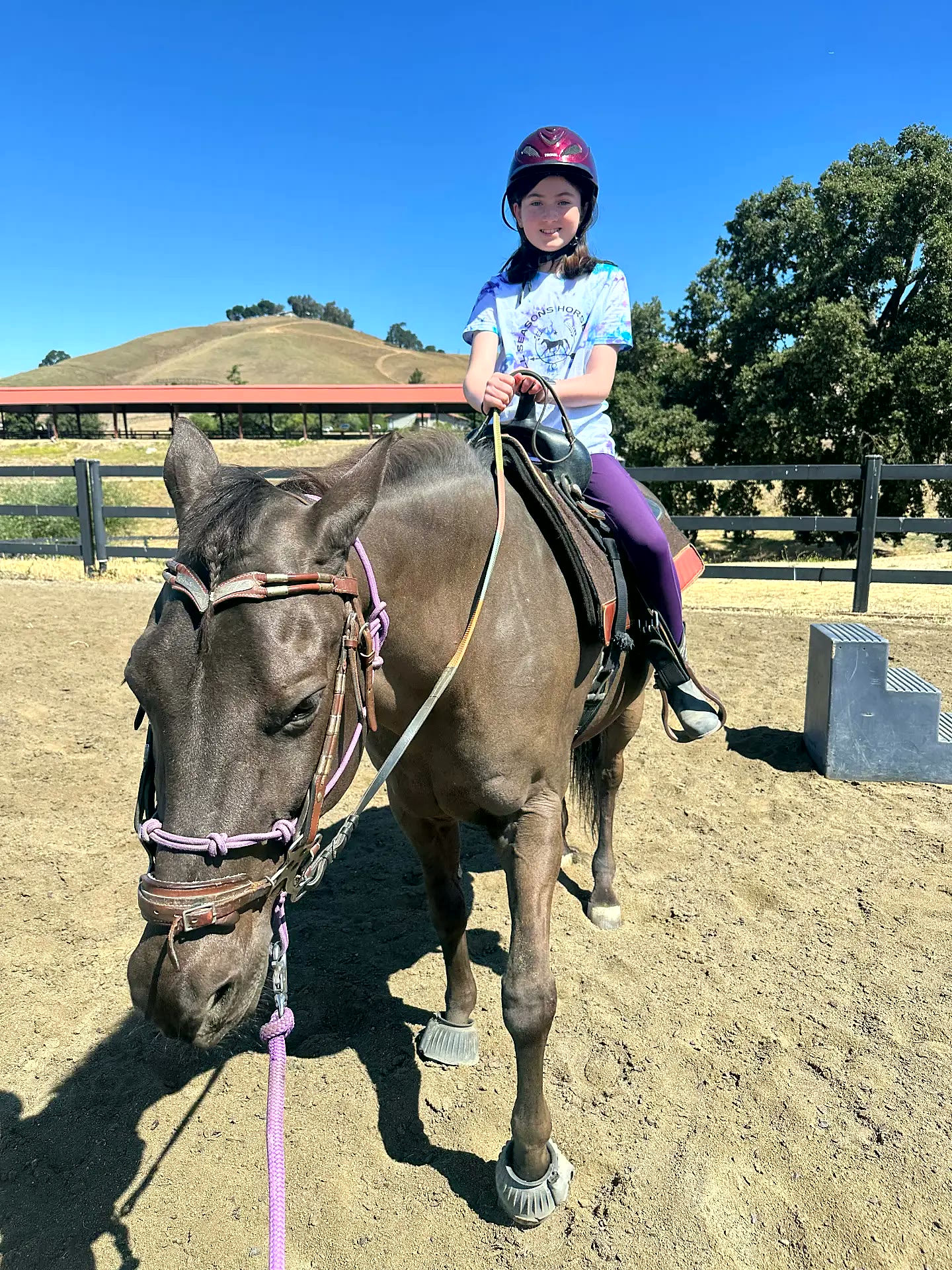 Young rider smiling in a western saddle in the arena